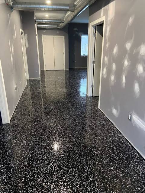 Glossy black speckled flake epoxy flooring in an interior showroom hallway, Las Vegas NV